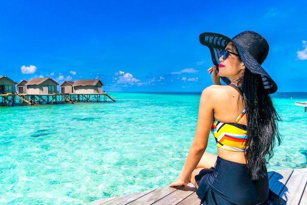 правила въезда на Мальдивы _Portrait of happy young woman at beautiful water villa at Maldiv