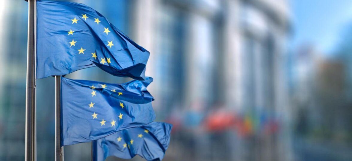 въед в Европу _european union flag against parliament brussels belgium