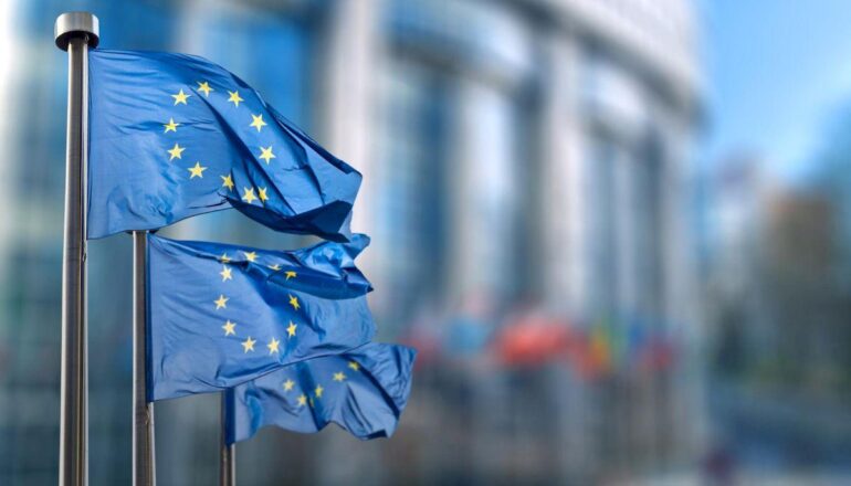 въед в Европу _european union flag against parliament brussels belgium