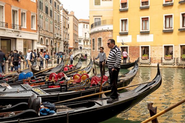 Новый туристический сбор в Венеции_gondoliers stand gondolas canal venice italy europe